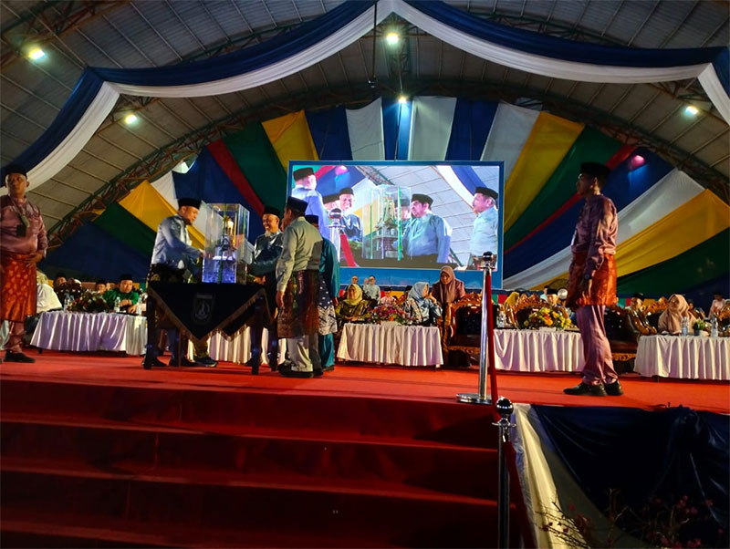 Asisten I Bidang Pemerintahan dan Kesra Setda Provinsi Riau Zulkifli Syukur MA Msi menyerahkan piala bergilir MTQ Riau kepada Kota Pekanbaru sebagai juara umum, Sabtu (27/4/2024) malam.