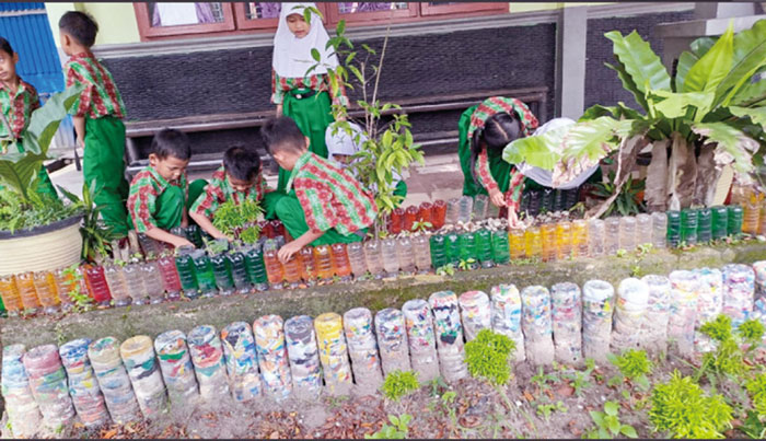 Murid SDN 187 Pekanbaru membersihkan dan memagari taman dengan ekobrik, Kamis (25/4/2024).