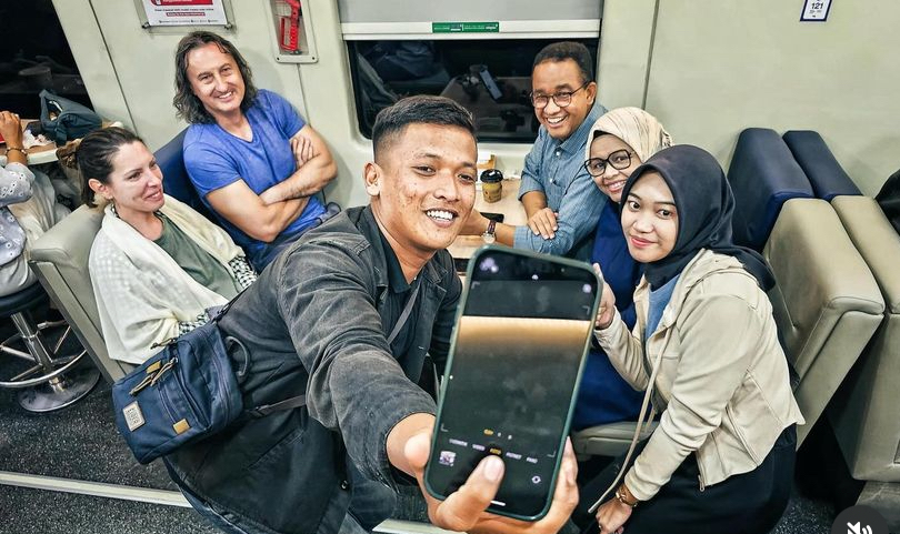 Anies Baswedan melalukan swafoto dengan masyarakat yang berada di kereta api.