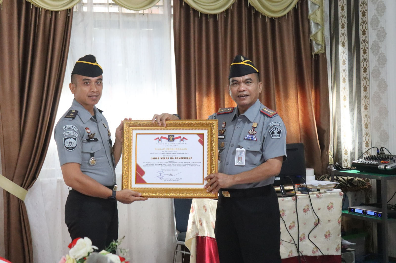 Kalapas Kelas IIA Bangkinang Mishbahuddin (kanan) menerima penghargaan Unit Pelaksana Teknis Terbaik di lingkungan Kantor Wilayah Kementerian Hukum dan HAM Riau, Senin (29/4/2024).