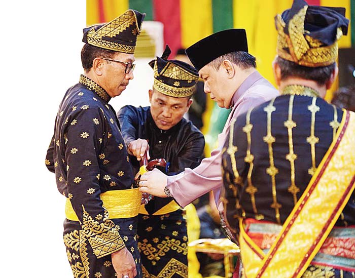 Penjabat Gubernur Riau SF Hariyanto memasangkan keris pada Kajati Riau Akmal Abbas saat menerima gelar Datuk Seri Lela Setia Junjungan Negeri.&nbsp;