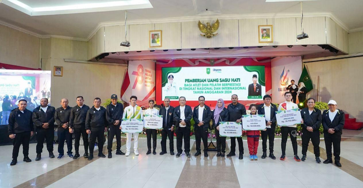 PJ Gubernur Riau SF Hariyanto, Kadispora Riau Erisman Yahya (kiri) bersama atlet dan pelatih berprestasi peraih medali foto bersama di Gedung Daerah, Jalan Diponegoro Pekanbaru, Kamis (2/5/2024).