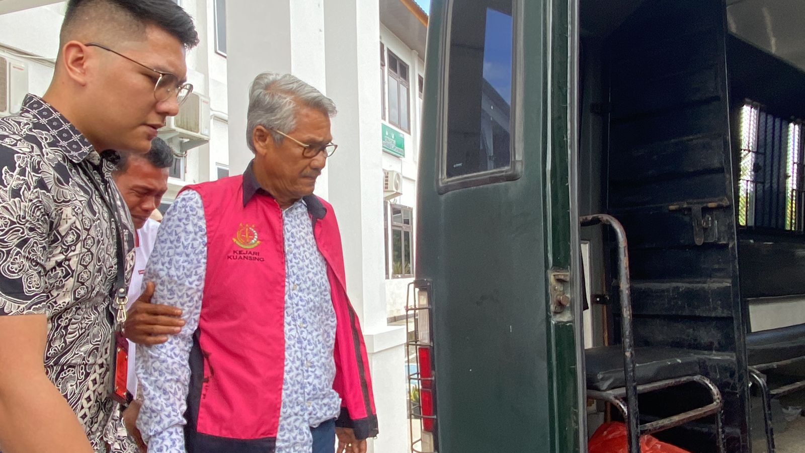 Mantan Bupati Kuansing Sukarmis saat akan memasuki mobil tahanan kejak&shy;saan usai menjalani pemeriksaan di Kejaksaan Negeri (Kejari) Kuansing, Jumat (3/5/2024).