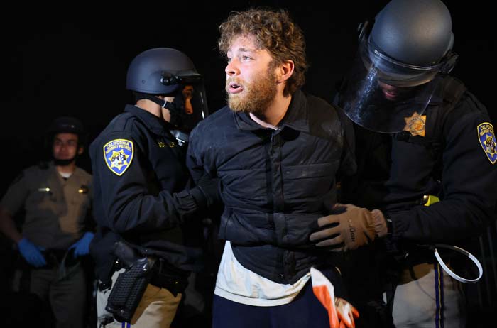 Petugas Patroli Jalan Raya California (CHP) menahan seorang pengunjuk rasa, saat membersihkan perkemahan pro-Palestina.