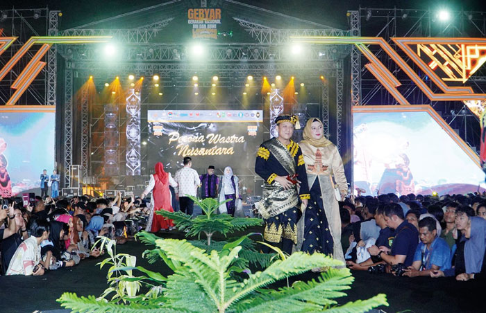 Pj Bupati Kampar dan istri saat tampil di acara fashion show &nbsp;gebyar Gerakan Nasional BBI, BBWI dan Lancang Kuning Carnival di halaman Kantor Gubernur Riau, Jumat malam (3/5/2024).