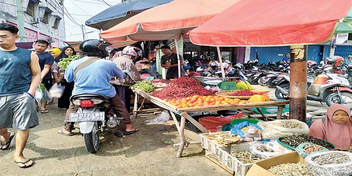 Salah seorang pedagang yang menggelar barang dagangan di Pasar Pulau Payung sedang menunggu datangnya calon pembeli, Senin (6/5/2024).