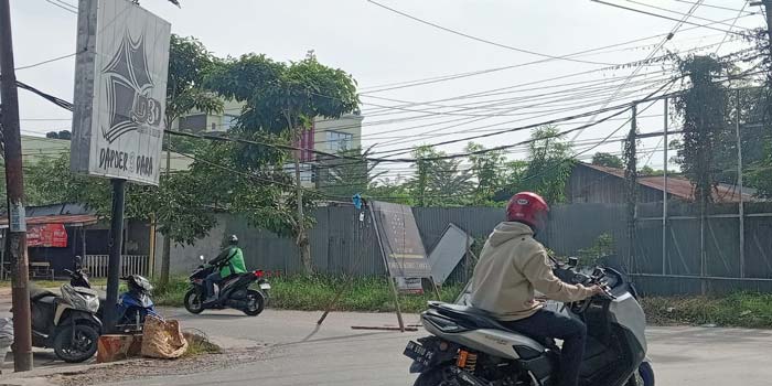 Pengendara sepeda motor berhati-hati saat melintasi kabel optik yang menjuntai di Jalan Rajawali Sakti, Kecamatan Binawidya, belum lama ini.
