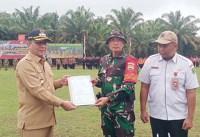 Wabup lnhu Drs H Junaidi Rachmat MSi menyerahkan naskah program TMMD ke-120 TA 2024 kepada Dandim 0302/Inhu Letkol Kav Dani Prasetyo Wibowo SSos MIP, Rabu (8/5/2024).