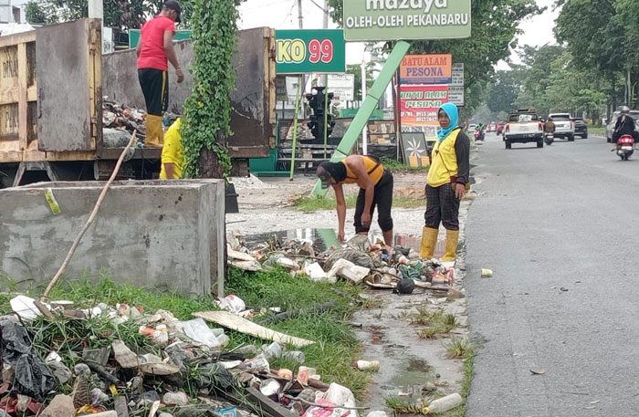 Para petugas dari Dinas PUPR  Pekanbaru mengeruk sampah yang dari drainase di Jalan Arifin Achmad, belum lama ini.