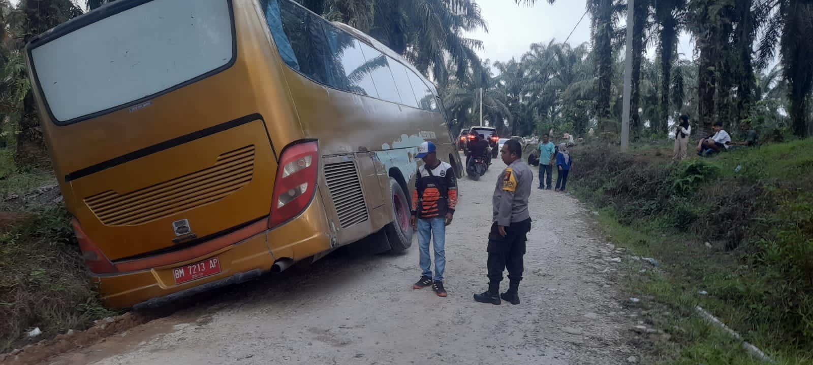 Personel Polsek XIII Koto Kampar membantu bus pariwisata yang terperosok di Henferd Land, Kecamatan XIII Koto, Kabupaten Kampar, Kamis (9/5/2024).