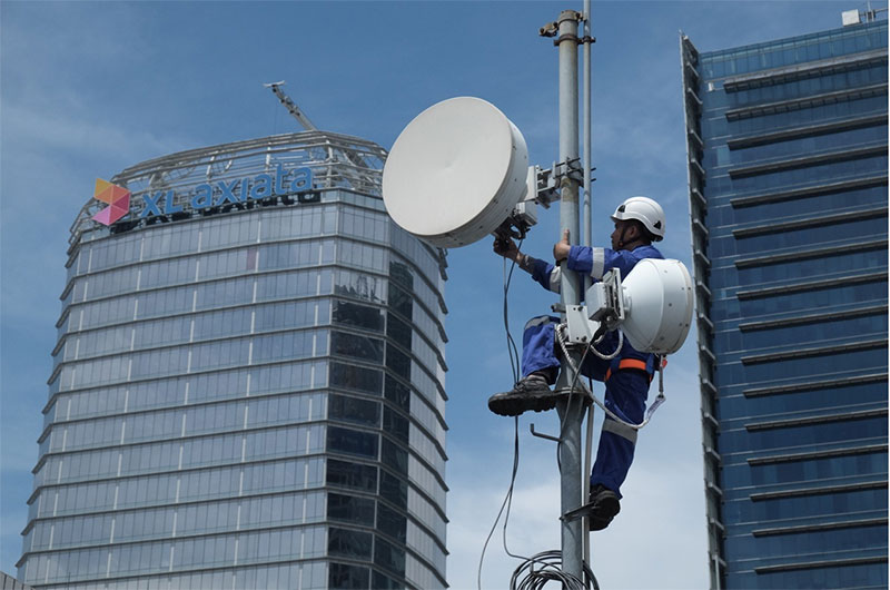 Seorang teknisi sedang memperbaiki jaringan XL Axiata di sebuah menara di Jakarta, belum lama ini.