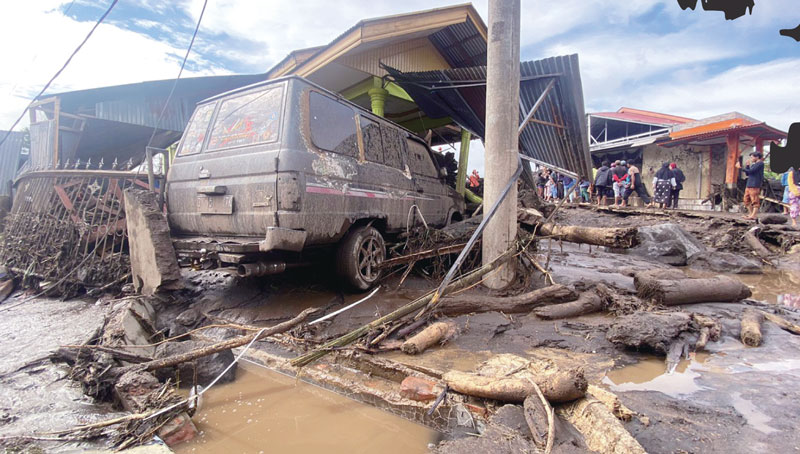 Warga mengevakuasi mobil yang terjebak banjir bandang.