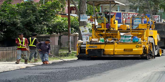 Para pekerja dibantu alat berat melakukan pengaspalan ulang (overlay) dalam upaya perbaikan Jalan Purwodadi, Kecamatan Tuah Madani, Senin (13/5/2024).