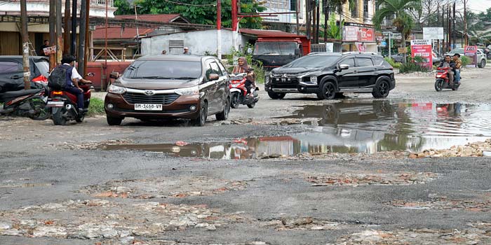 Kendaraan bermotor melintas di Jalan Rajawali, Kecamatan Sukajadi yang banyak terdapat lubang-lubang besar dan tergenang, Senin (13/5/2024).