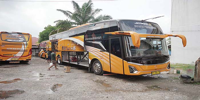 Pekerja membersihkan bus di Kantor Bus Fajar Riau Wisata (FRW) Jalan Soekarno Hatta, Pekanbaru, Selasa (14/5/2024). Dampak bencana alam yang terjadi di Provinsi Sumatera Barat.