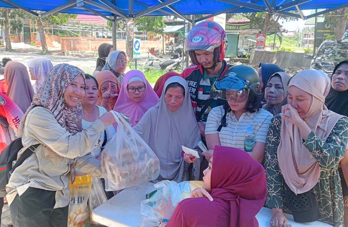 Warga yang didominasi kaum emak-emak tersenyum karena bisa membeli bahan pokok dengan harga terjangkau dalam program mobil Pak Iwan di Kecamatan Binawidya.