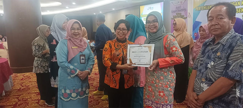 Direktur Bina Ketahanan Keluarga Lansia dan Rentan BKKBN RI dr Niluh Gede Sukardiasih didampingi Kaper BKKBN Riau Mardalena Wati Yulia menyerahkan sertifikat kepada kabupaten/kota