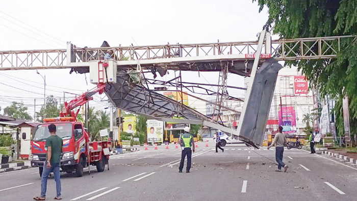 Petugas gabungan dari Pemkab Bengkalis dan Polres Bengkalis  membongkar papan reklame di Jalan Sudirman Kota Bengkalis, Sabtu (18/5/2024).