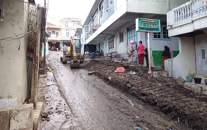 Petugas menggunakan alat berat saat membersihkan sisa material banjir bandang di Nagari Koto Tuo Kecamatan IV Koto, Kabupaten Agam, Senin (20/5/2024).