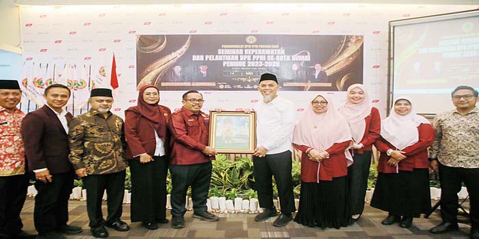 Ketua PPNI Riau Ahmad Yusuf menyerahkan gambar karikatur kepada Wali Kota Dumai H Paisal, usai menghadiri pelantikan Dewan Pengurus Komisariat Persatuan Perawat Nasional Indonesia (DPK PPNI) Dumai.