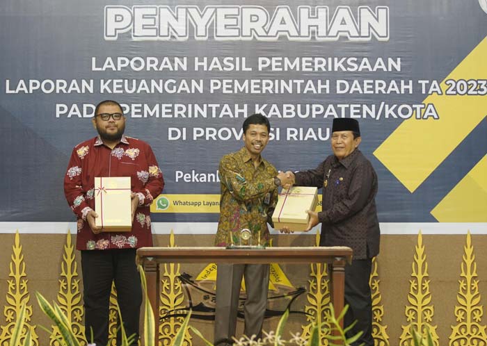Kepala BPK Perwakilan Riau Jariyatna SE MM Ak (tengah) menyerahkan LHP terhadap audit LKPD Rohul Tahun Anggaran 2023 kepada Bupati Rohul H Sukiman.