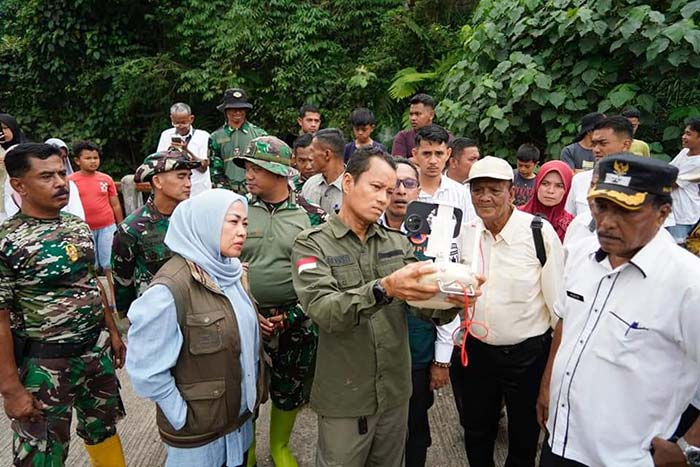 Bupati Tanahdatar Eka Putra (tengah) menggunakan drone saat melihat kondisi aliran sungai di Jorong Lumbung Bapereng, Nagari Pasie Laweh, Tanahdatar, Sumatera Barat, Rabu (22/5/2024).