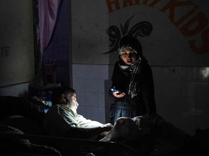 SENTER PONSEL: Seorang wanita menggunakan senter ponsel saat mengunjungi pasien di Rumah Sakit Martir Al-Aqsa, Deir al-Balah, Jumat (24/5/2024).