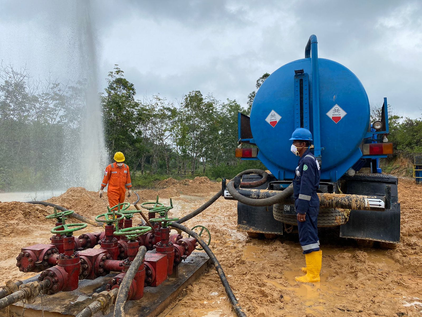Petugas PEP Lirik Field melakukan vakum air bercampur tanah yang menyembur untuk di&shy;pin&shy;dahkan ke area pe&shy;numpukan Pertamina di Sungai Karas, Lirik,  Indragiri Hulu, Jumat (24/5/2024).
