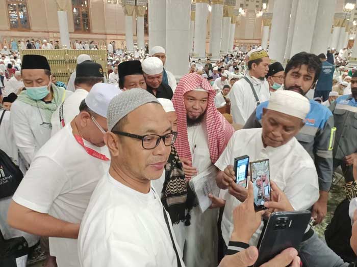 Ustad Ariful Arif (bersurban) diajak berfoto para jamaah Indonesia seusai pengajian rutin di Masjid Nabawi.