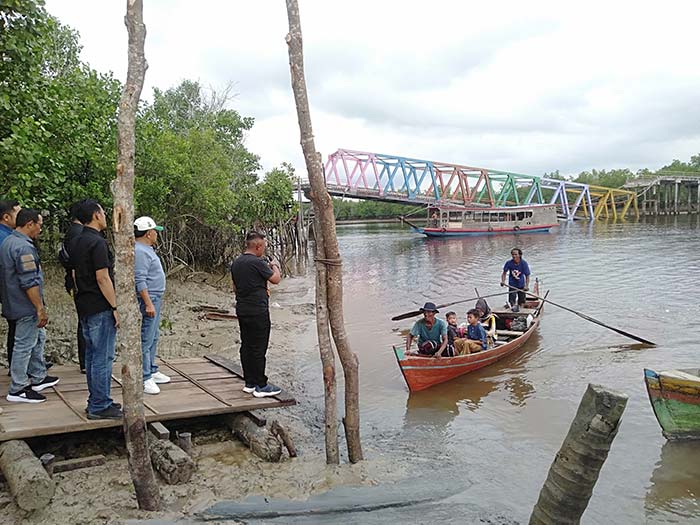 Warga menggunakan jasa angkutan perahu ketika melewati Sungai Perumbi, Kecamatan Tebingtinggi Barat, Kepulauan Meranti, Ahad (26/5/2024)