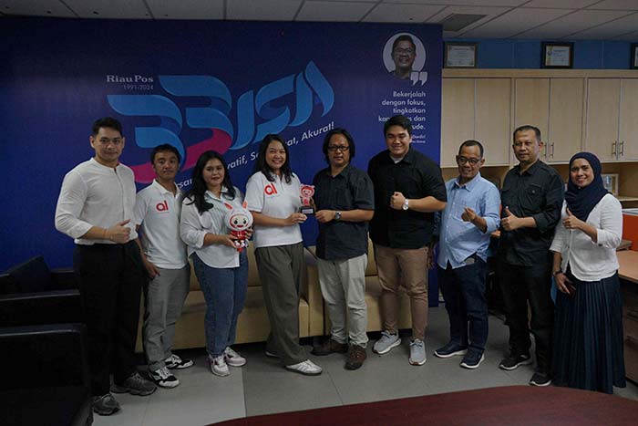 Senior Legal Manager PT Akulaku Finance Indonesia Rinjani Indah Lestari (empat kiri) menyerahkan cendera mata kepada Direktur Riau Pos Firman Agus (lima kanan).