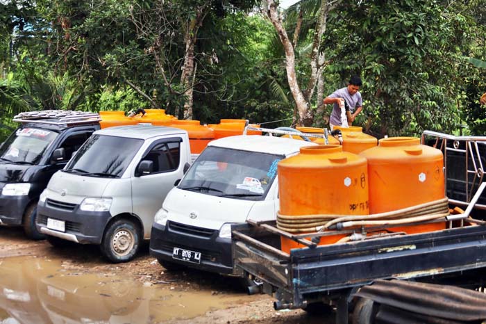 Para pekerja mengisi toren-toren air yang diangkut menggunakan mobil Daihatsu Gran Max di Jalan Ring Road III, Kelurahan Sempaja Selatan, Kecamatan Samarinda Utara.