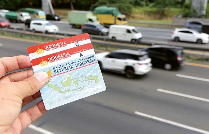 KEBIJAKAN BARU: Foto ilustrasi SIM dan KTP dengan latar belakang kendaraan yang melintasi tol Tangerang-Tomang kemarin (24/5).