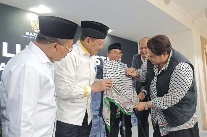 Desainer Ivan Gunawan membubuhkan tanda tangan di hijab hasil karyanya di Jakarta, Senin (3/6/2024).