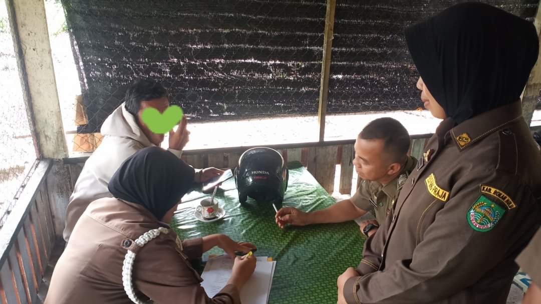 Personil Satpol PP Rohul sedang mendata sejumlah ASN dan Non ASN yang terjaring razia penegakan disiplin saat nongkrong di sebuah warung pada jam kerja, Selasa (4/6/2024).