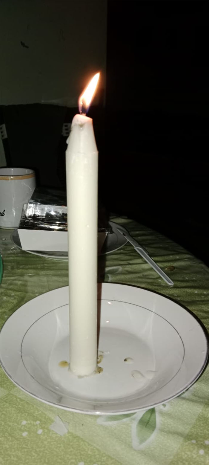 Warga menyalakan lilin untuk penerangan