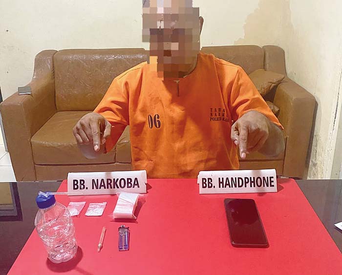 AM (49) tersangka  narkoba menunjuk barang bukti sabu-sabu saat di Mapolres Kampar, baru-baru ini.