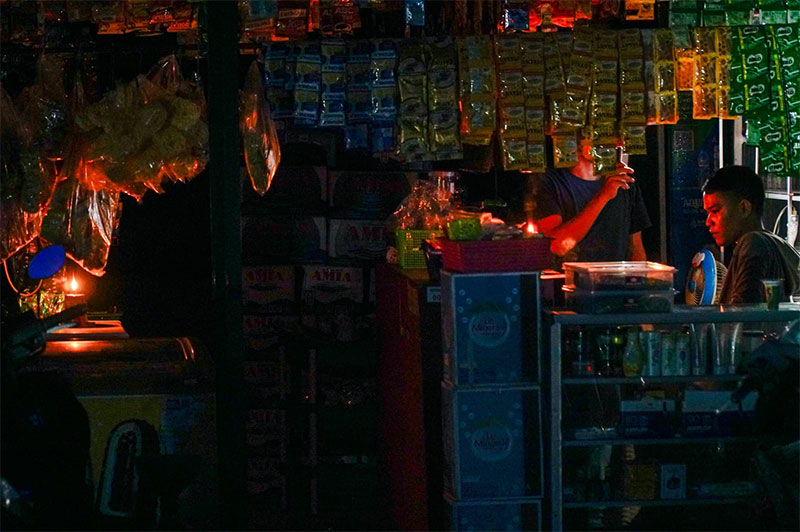 Kedai harian menggunakan lilin dan lampu emergency sebagai penerangan di alan Cipta Karya, Rabu (5/6/2024). PLN melakukan pemadaman bergilir karena adanya pemeliharaan jaringan.