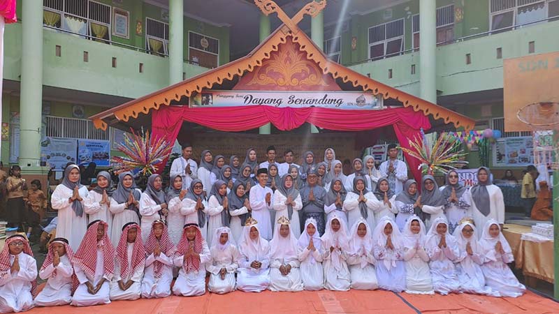 Kepala SDN 148 Pekanbaru Sumarni SPd (sembilan kanan berdiri depan), majelis guru dan murid kelas VI saat pelaksanaan perpisahan, khatam Al-Qur&rsquo;an dan gelar karya P5 di halam