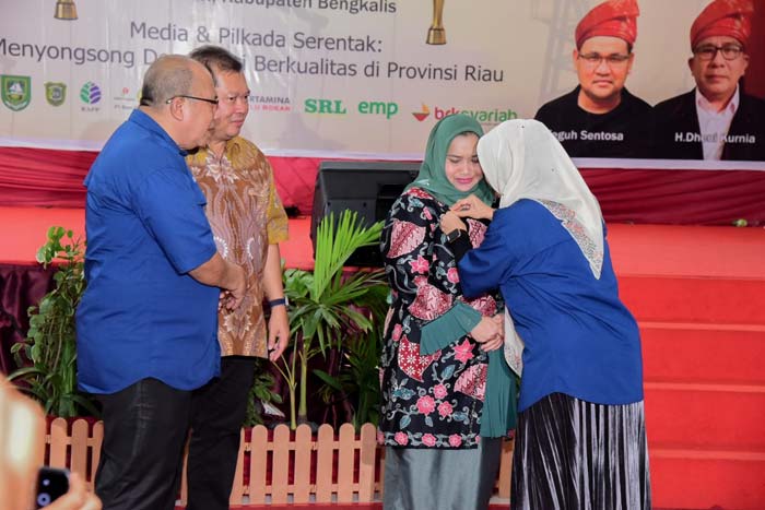 Pengurus JMSI Pusat memasangkan Pin Emas kepada Bupati Bengkalis Kasmarni pada puncak peringatan Hari Pers Nasional (HPN) dan Hari Ulang Tahun ke-4 JMSI dan JMSI Award.