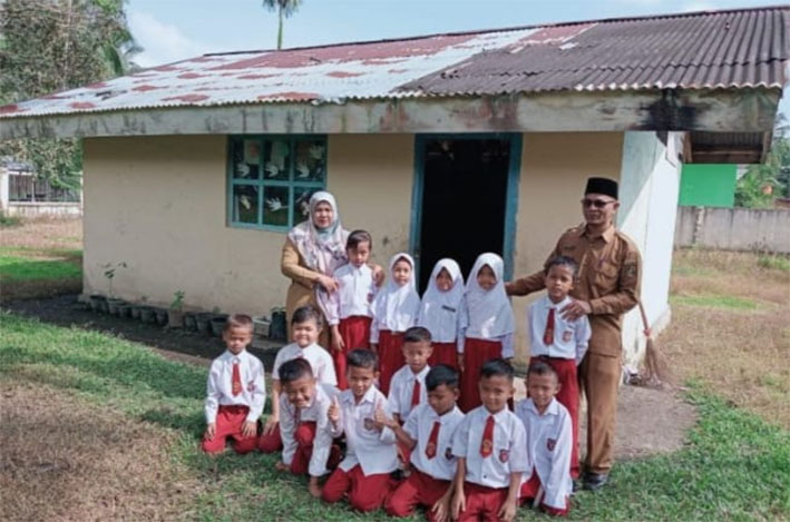 Plt Kasek SDN 02 Desa Tanjung Apriwardi, guru kelas dan murid kelas 1A foto bersama di depan kelas bekas toilet, Rabu (12/6/2024).
