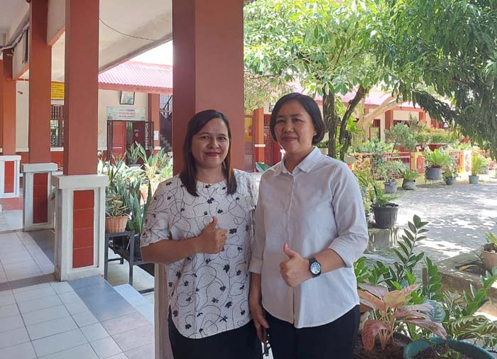 Kepala SD Santa Maria II Pekanbaru Jenny FP Sihotang (kanan) bersama Wakil Kepala Bidang Kesiswaan Andriani Saragih berfoto di sekolahnya yang hijau, Rabu (5/6/2024).