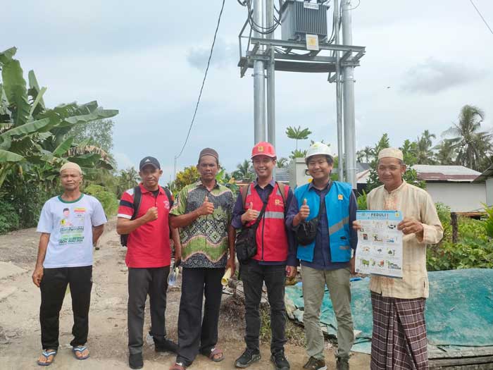 Petugas PLN foto bersama masyarakat Desa Simpang Kateman, Kecamatan Pelangiran, Kabupaten Indragiri Hilir.