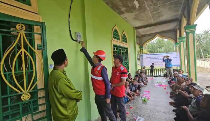Petugas PLN menghidupkan aliran listrik disaksikan masyarakat Desa Simpang Kateman, Kecamatan Pelangiran, Kabupaten Indragiri Hilir.