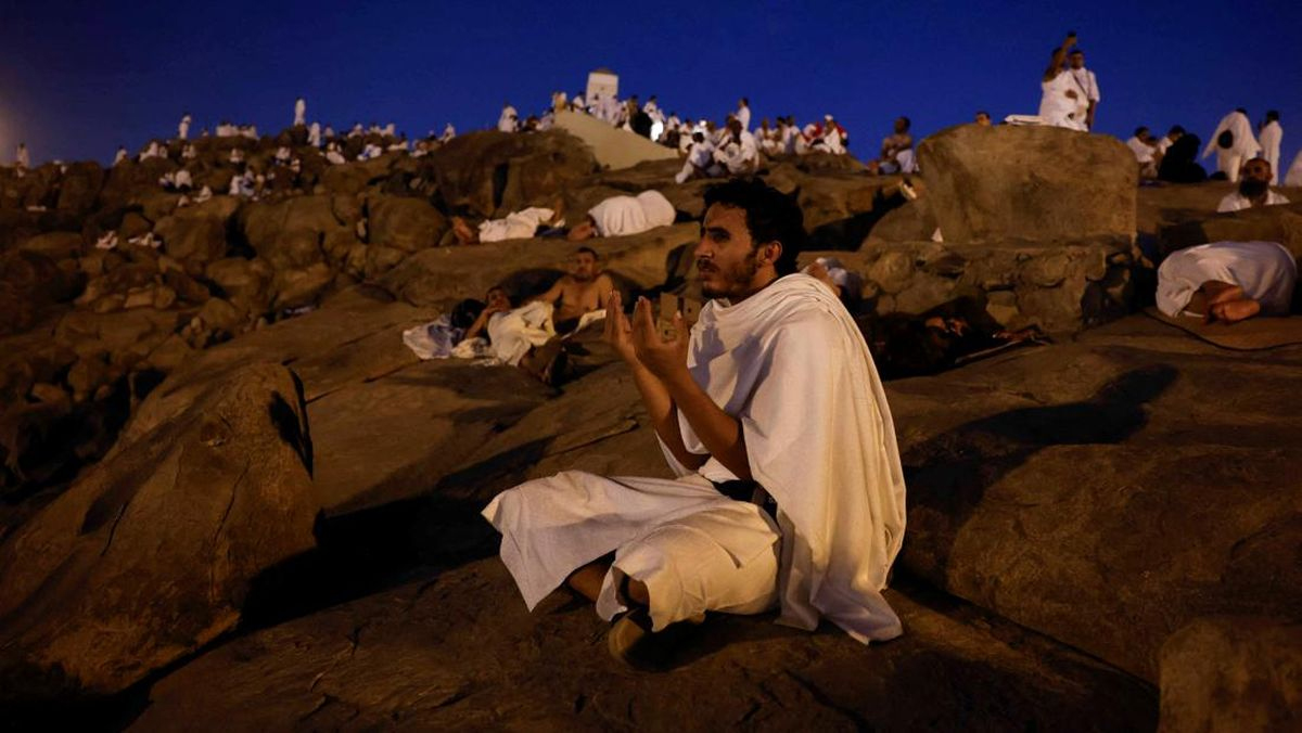 Seorang jemaah haji berdoa dengan latar belakang ratusan jemaah lainnya di bebatuan kawasan Arafah, Sabtu (15/6/2024). Jutaan jemaah haji berkumpul di Arafah untuk melaksanakan puncak ibadah haji, y