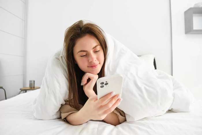 ilustrasi pakai handphone sebelum tidur.