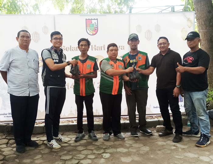 Kepala UPT Perparkiran Dishub Pekanbaru Radinal Munandar (tiga kiri) dan perwakilan PT YSM Iwan Sunadi (dua kanan) menyerahkan bantuan paket daging kurban kepada perwakilan jukir, Selasa (18/6/2024).