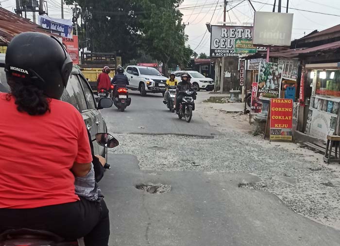 Pengendara melewati Jalan Kartama/Inpres, Kecamatan Marpoyan Damai yang rusak dan belum dilakukan perbaikan, Selasa (18/6/2024).