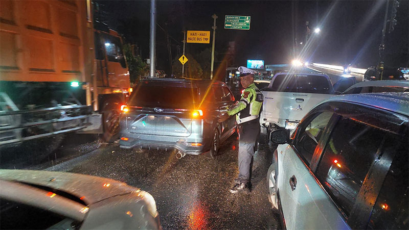 Anggota Satlantas Polresta Pekanbaru mengatur lalu lintas yang macet di tengah hujan Jalan HR Soebrantas Pekanbaru Jumat (21/6/2024) malam sekitar pukul 22.30 WIB .