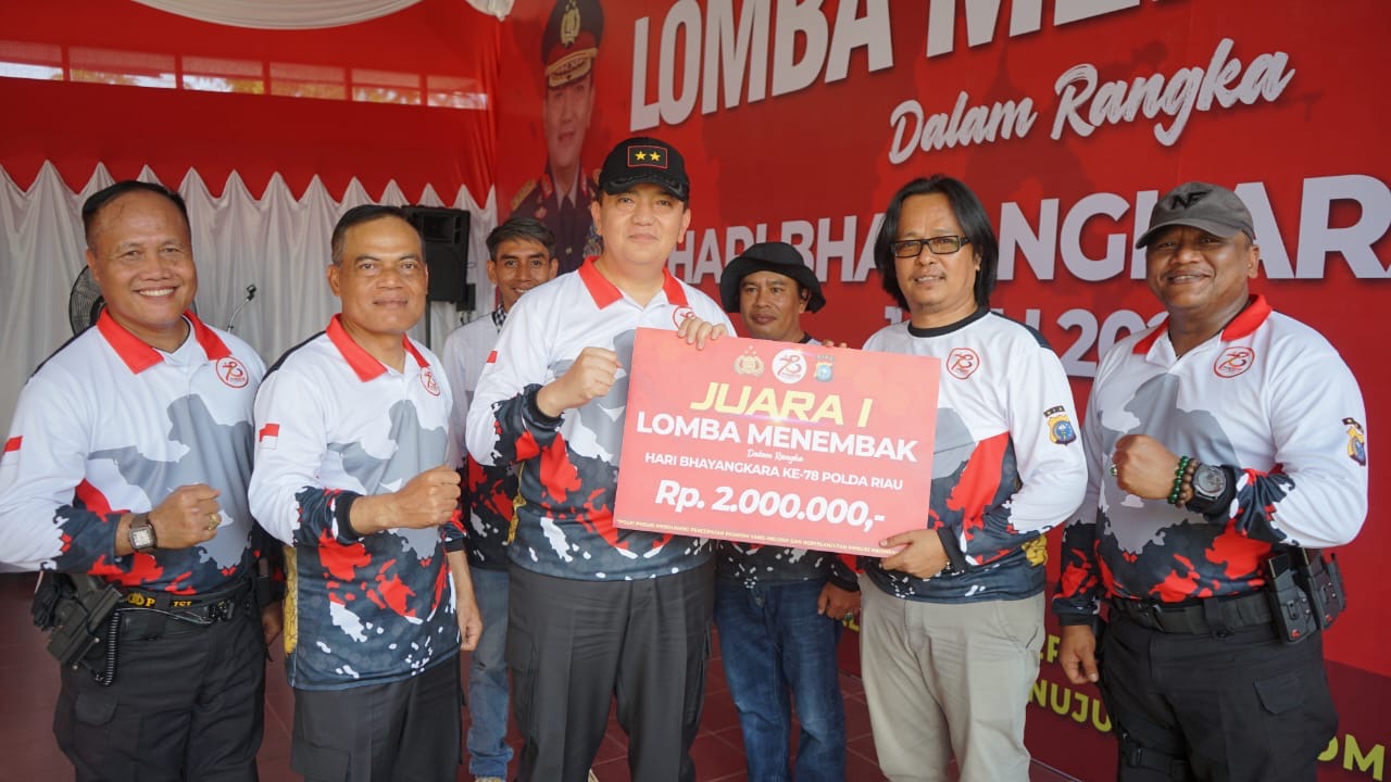 Kapolda Riau Irjen Pol Mohammad Iqbal didampingi Wakapolda Riau Brigjen Pol K Rahmadi memberikan hadiah kepada Pemimpin Redaksi Riau Pos Firman Agus yang memenangkan Juara 1  Lomba Menembak.